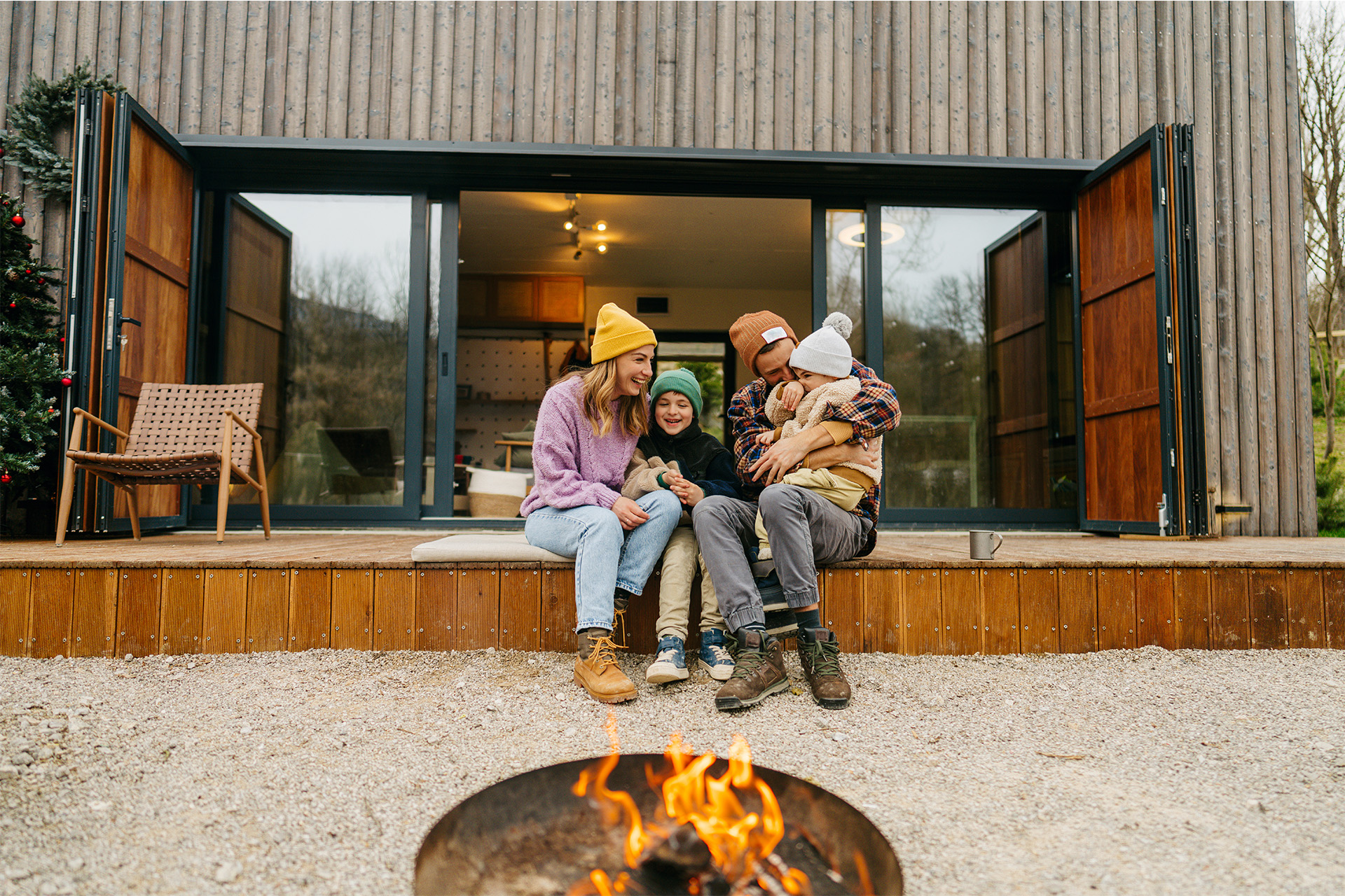 Gemütliche Terrasse vor Holzfassade – Familie genießt den Außenbereich Familie sitzt entspannt auf einer Terrasse vor einem Holzhaus mit moderner Holzfassade.